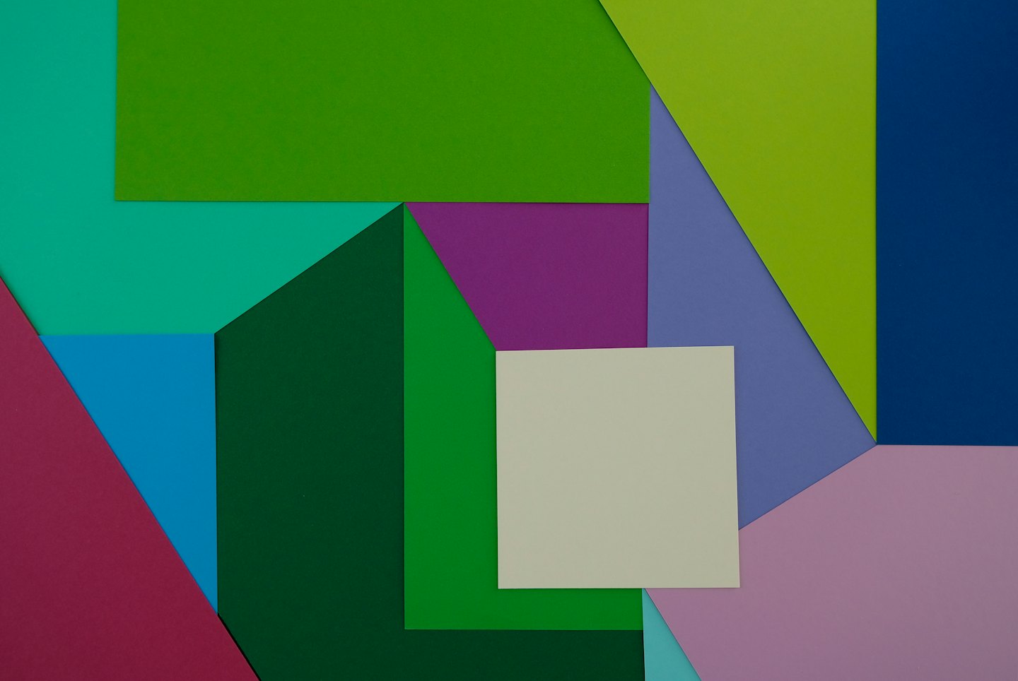 Colorful paper shapes overlap creating a modern geometric design.